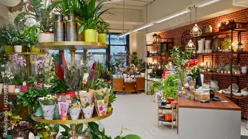Beautiful atmospheric flower shop with decorations. Stylish interior design with plants, pots, and furniture 