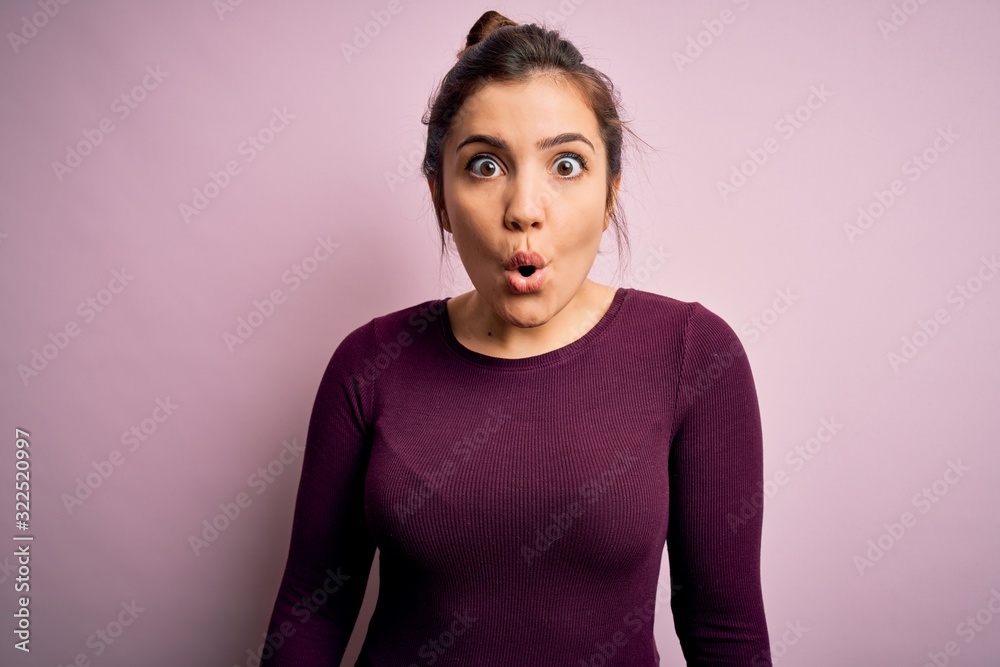 Beautiful young woman wearing casual bun hairstyle over pink isolated background afraid and shocked with surprise expression, fear and excited face. Beautiful young woman wearing casual bun hairstyle over pink isolated background afraid and shocked with surprise expression, fear and excited face.