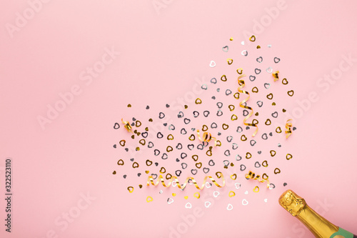 Champagne bottle with hearts golden confetti on pink