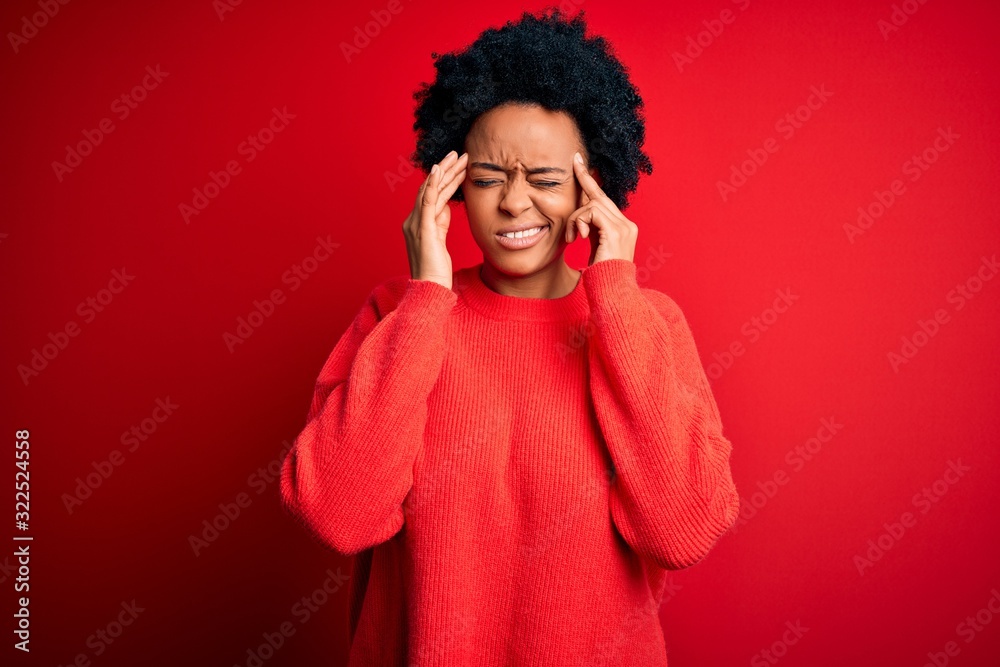 Young beautiful African American afro woman with curly hair wearing casual sweater with hand on head for pain in head because stress. Suffering migraine.