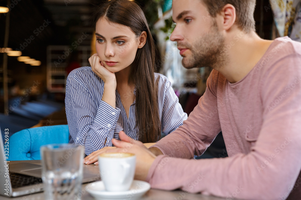 Attractive young couple having lunch at the cafe indoors Attractive young couple having lunch at the cafe indoors