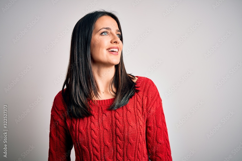 Young brunette woman with blue eyes wearing casual sweater over isolated white background looking away to side with smile on face, natural expression. Laughing confident. Young brunette woman with blue eyes wearing casual sweater over isolated white background looking away to side with smile on face, natural expression. Laughing confident.