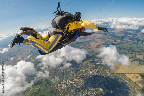 Fototapeta Skydive tandem free falling above the clouds