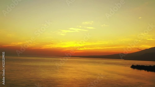 Golden glowing sunset over a large body of water in outback Indonesia captured from the air photo