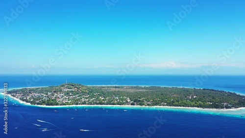Paradise vacation destination, tropical island with lush vegetation surrounded by blue azure sea water under a bright clear sky, gili trawangan, Indonesia