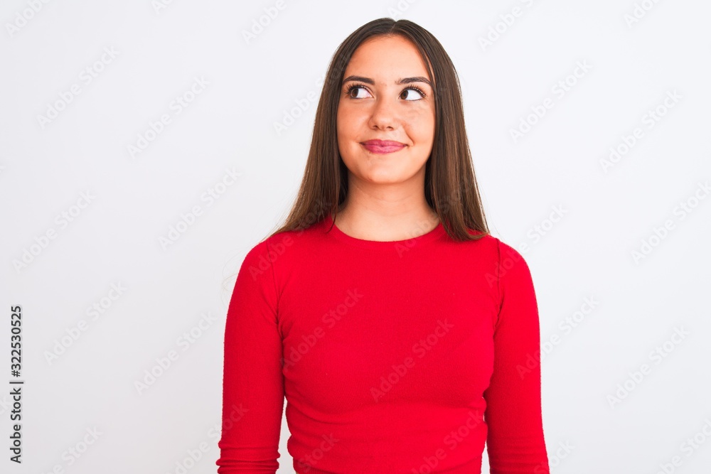 Young beautiful girl wearing red casual t-shirt standing over isolated white background smiling looking to the side and staring away thinking. Young beautiful girl wearing red casual t-shirt standing over isolated white background smiling looking to the side and staring away thinking.
