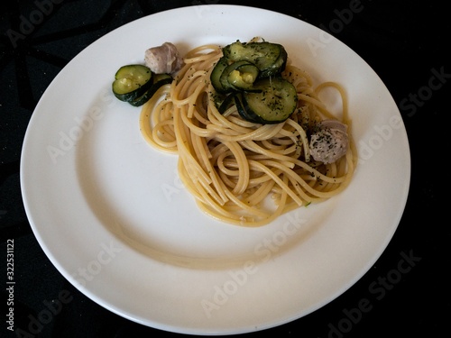 a dish of italian Gragnano doc spaghetti with sautéed courgettes and sausage photo