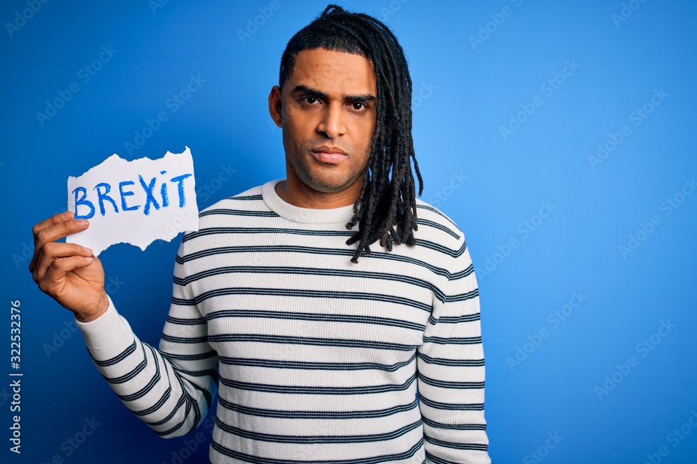 Naklejka premium Young african american afro man holding banner with brexit message over blue background with a confident expression on smart face thinking serious