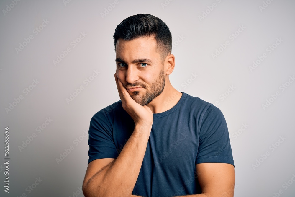Young handsome man wearing casual t-shirt standing over isolated white background thinking looking tired and bored with depression problems with crossed arms. Young handsome man wearing casual t-shirt standing over isolated white background thinking looking tired and bored with depression problems with crossed arms.