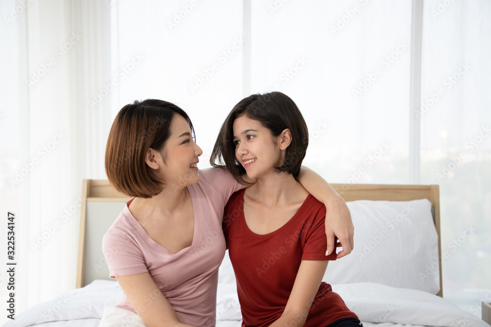 A couple of lovely woman having hug and holding hands while smiling and looking eyes on bedroom. They are happiness and building good relationships in the future.