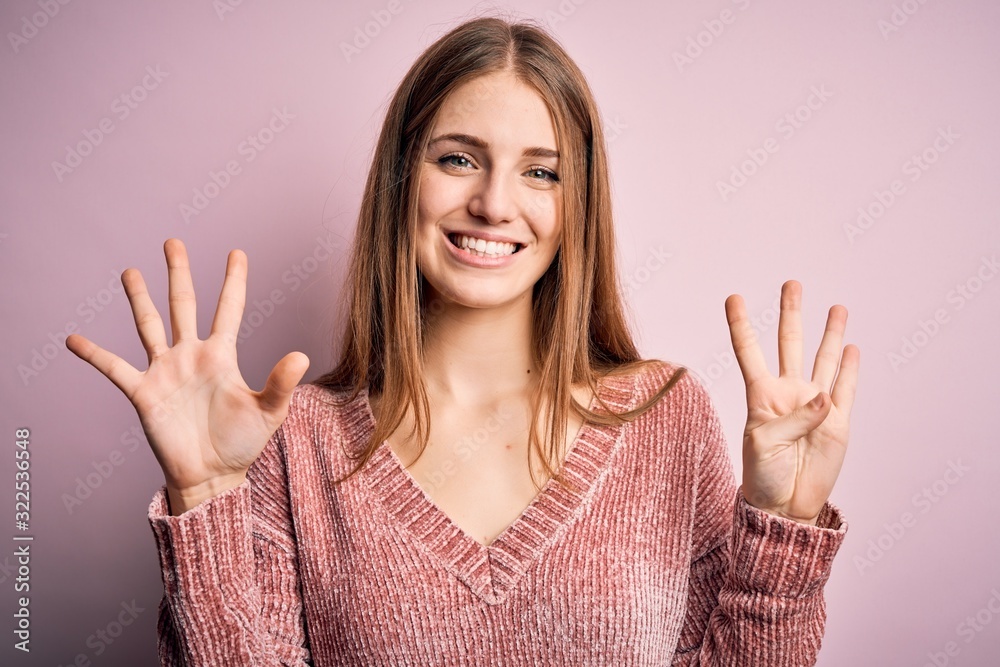 Young beautiful redhead woman wearing casual sweater over isolated pink background showing and pointing up with fingers number nine while smiling confident and happy. Young beautiful redhead woman wearing casual sweater over isolated pink background showing and pointing up with fingers number nine while smiling confident and happy.
