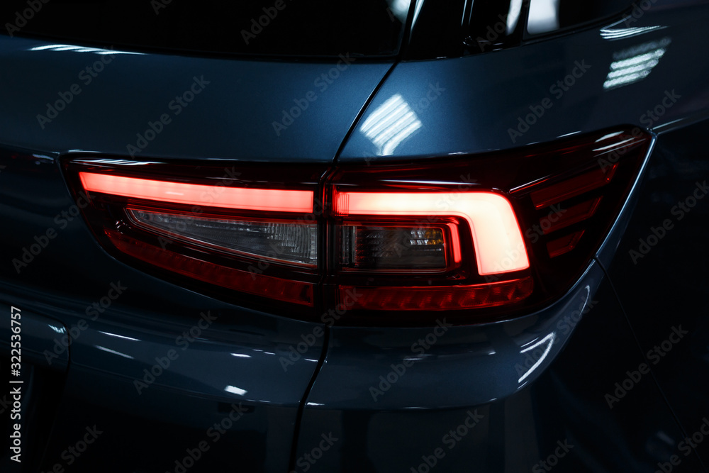 Detail on the rear light of a car. Car detail. Developed Car's rear brake light. The car is in the showroom. Automotive concept. Classic blue color