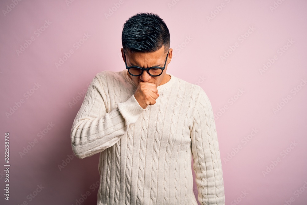 Young handsome latin man wearing white casual sweater and glasses over pink background feeling unwell and coughing as symptom for cold or bronchitis. Health care concept. Young handsome latin man wearing white casual sweater and glasses over pink background feeling unwell and coughing as symptom for cold or bronchitis. Health care concept.