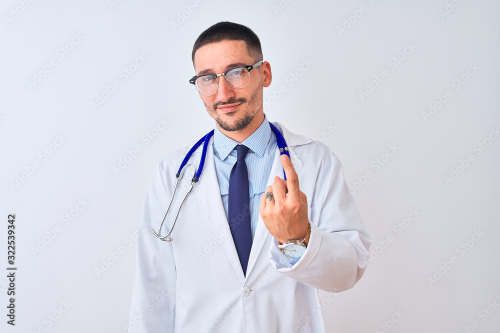 Young doctor man wearing stethoscope over isolated background Beckoning come here gesture with hand inviting welcoming happy and smiling Young doctor man wearing stethoscope over isolated background Beckoning come here gesture with hand inviting welcoming happy and smiling