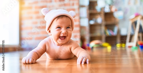 Bilde på lerret Adorable baby lying down on the sofa smiling happy at home