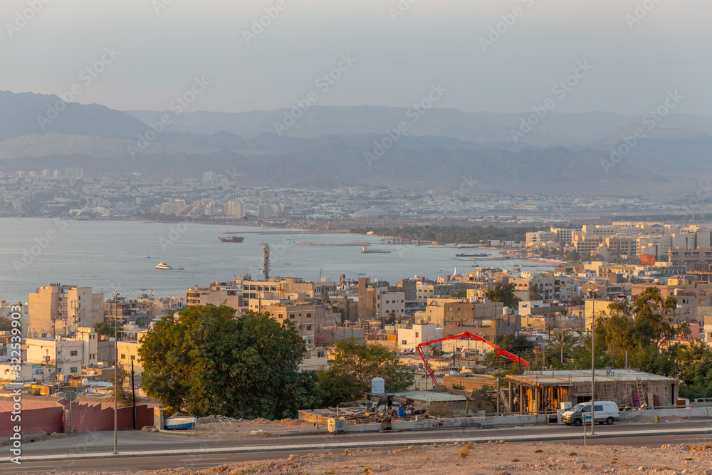 Fototapeta premium Zachód słońca w mieście Akaba, widok na miasto Ejlat w Izraelu. Miasto Akaba, Jordania