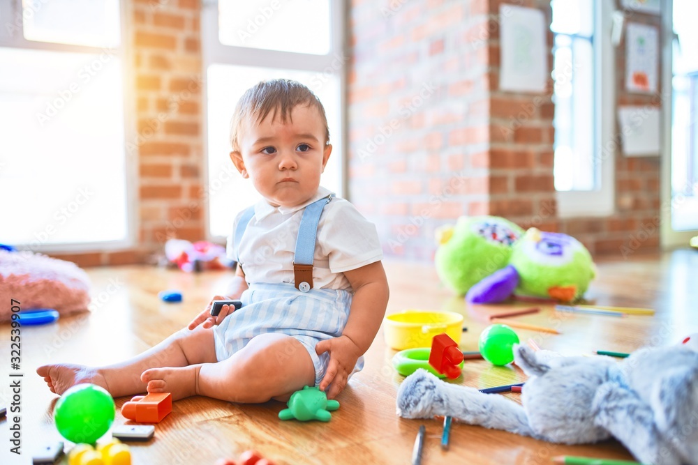 Adorable toddler playing around lots of toys at kindergarten Adorable toddler playing around lots of toys at kindergarten
