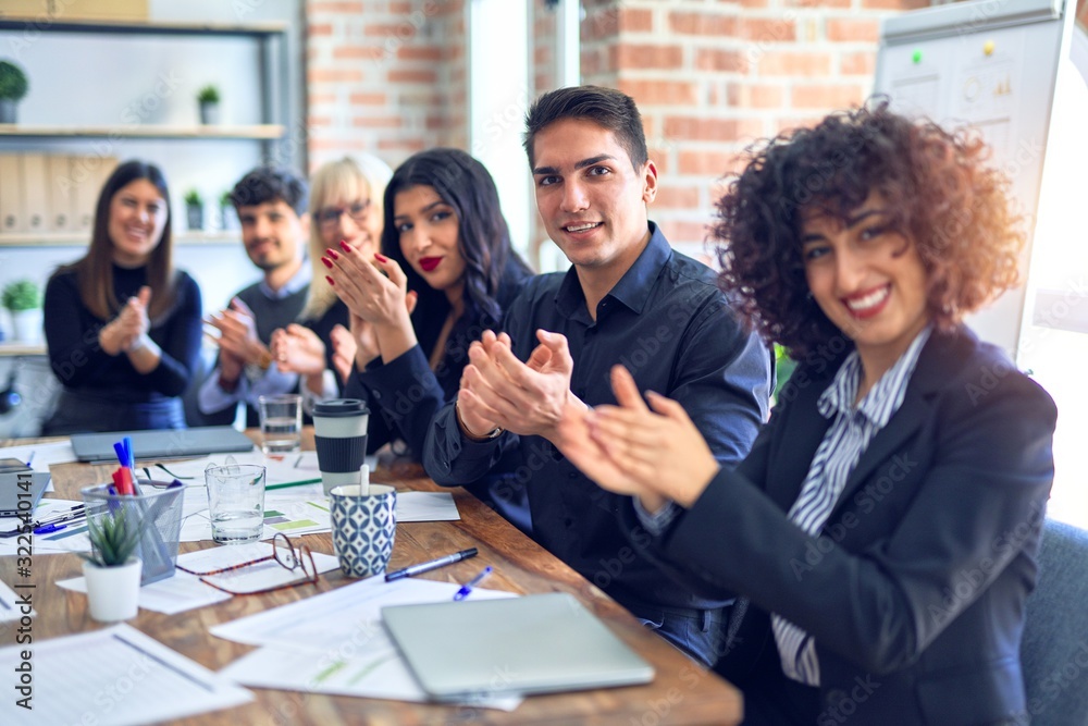 Group of business workers smiling happy and confident. Working together with smile on face looking at the camera applauding at the office Group of business workers smiling happy and confident. Working together with smile on face looking at the camera applauding at the office