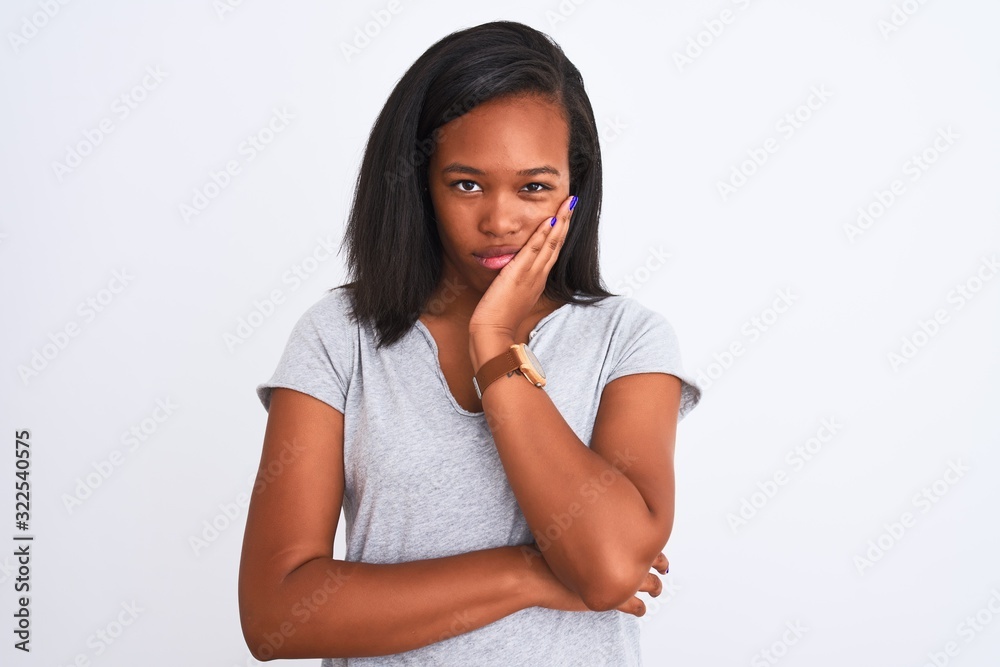 Beautiful young african american woman wearing casual t-shirt over isolated background thinking looking tired and bored with depression problems with crossed arms. Beautiful young african american woman wearing casual t-shirt over isolated background thinking looking tired and bored with depression problems with crossed arms.