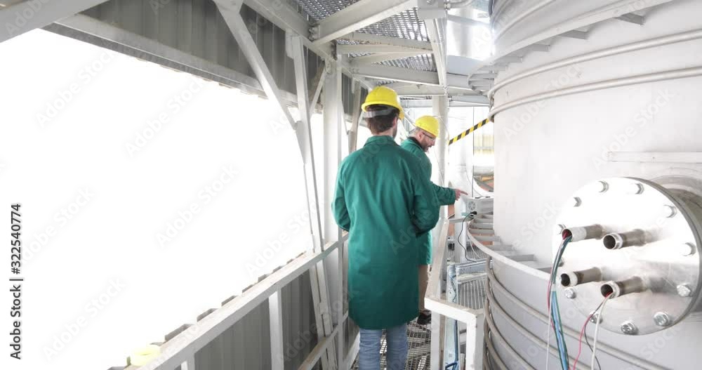 Due ingegneri energetici stanno controllando la cisterna in pressione di un apparato per l'energia