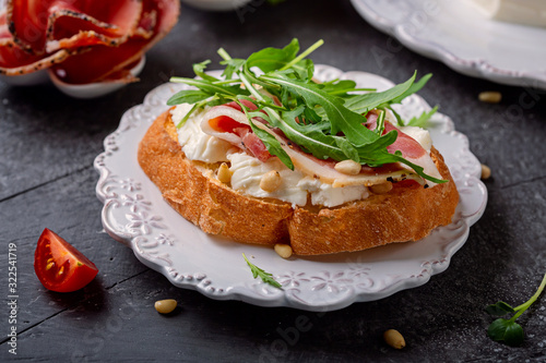 Tableau sur toile Sandwich with Italian  cheese Stracchino , arugula, prosciutto and pine nuts