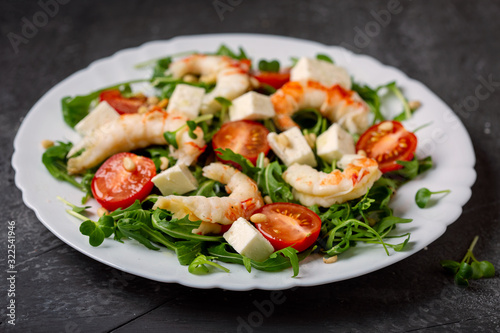 Salad with arugula, shrimp, cheese and fresh tomatoes