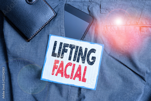 Text sign showing Lifting Facial. Business photo showcasing plastic surgery on the face and neck to remove defects Smartphone device inside trousers front pocket with wallet and note paper photo