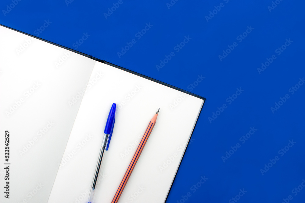 School and office supplies flay lay on colorful blue background. Opened notebook, sketchbook, pen and pencil. Top view with copy space. Back to school concept. Banner template for web. Stock photo. School and office supplies flay lay on colorful blue background. Opened notebook, sketchbook, pen and pencil. Top view with copy space. Back to school concept. Banner template for web. Stock photo.