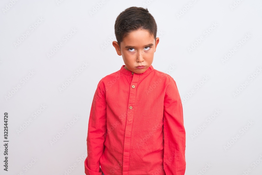 Beautiful kid boy wearing elegant red shirt standing over isolated white background skeptic and nervous, frowning upset because of problem. Negative person. Beautiful kid boy wearing elegant red shirt standing over isolated white background skeptic and nervous, frowning upset because of problem. Negative person.