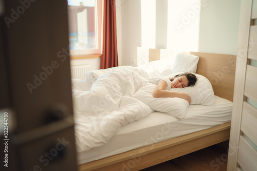 Young beautiful alone woman sleeping on bed in bedroom