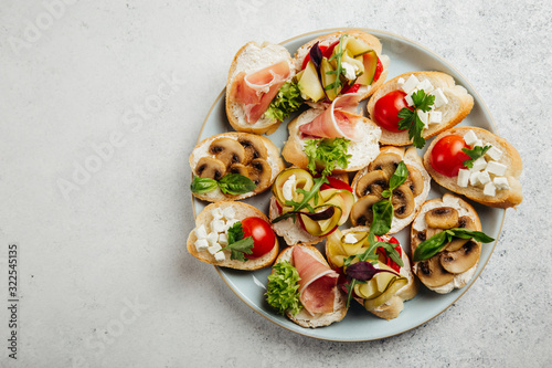 portioned snacks canapes and sandwiches with meat, cheese and vegetables