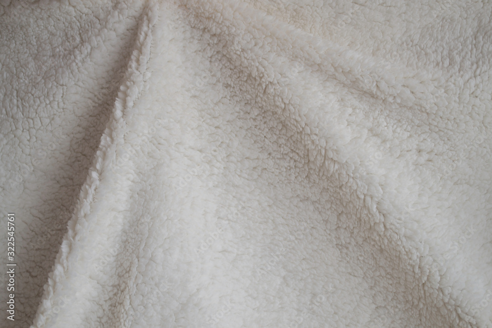 Texture of a soft plaid. Crumpled white warm blanket. Fabric for background or wallpaper.