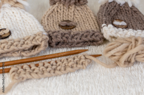 knitting themed background in neutral beige colours with pompom hats 