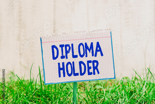 Word writing text Diploma Holder. Business photo showcasing a demonstrating successfully completed a particular course of study Mathematic paper attached to a stick and placed in the green grassy land photo