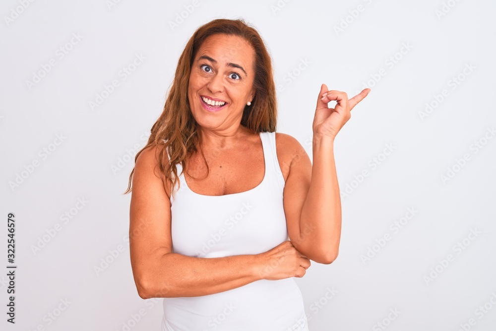 Middle age mature woman standing over white isolated background with a big smile on face, pointing with hand finger to the side looking at the camera. Middle age mature woman standing over white isolated background with a big smile on face, pointing with hand finger to the side looking at the camera.
