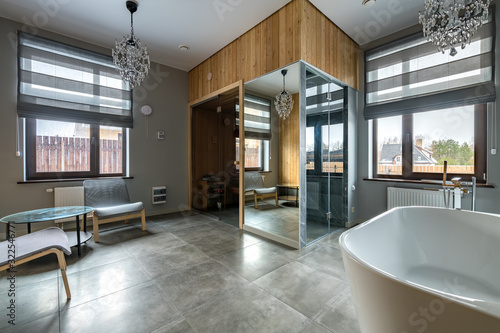 Luxury bathroom with white bathroom, glass shower, sauna. The combination of marble and wood in interior design © Мария Дмитриева