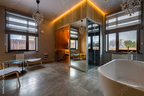 Luxury bathroom with white bathroom, glass shower, sauna. The combination of marble and wood in interior design photo