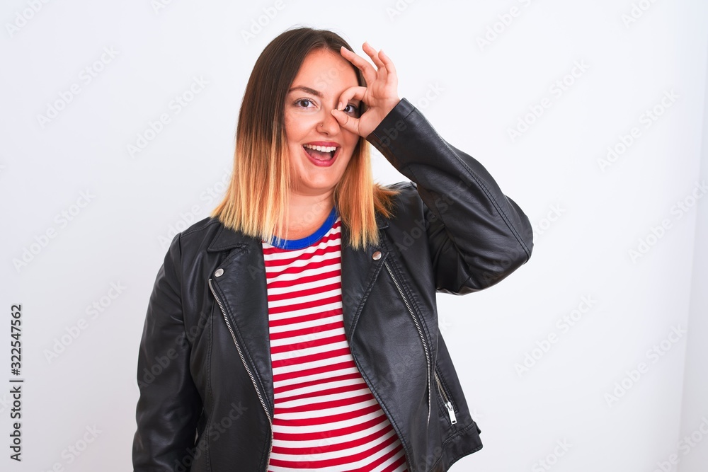 Young beautiful woman wearing striped shirt and jacket over isolated white background doing ok gesture with hand smiling, eye looking through fingers with happy face. Young beautiful woman wearing striped shirt and jacket over isolated white background doing ok gesture with hand smiling, eye looking through fingers with happy face.