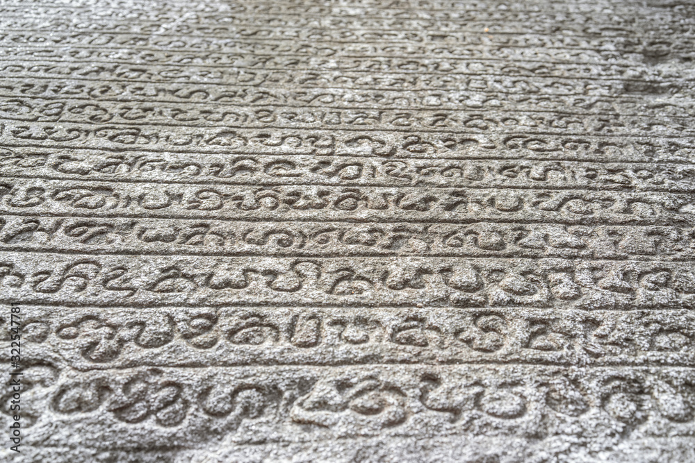 Sinhalese language stone book on wall of 12th century stone Hindu structure. Polonnaruwa, Sri Lanka. UNESCO World heritage Site. Sinhalese language stone book on wall of 12th century stone Hindu structure. Polonnaruwa, Sri Lanka. UNESCO World heritage Site.