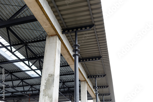 Aluminum roof with windows on a metal frame. Iron columns support the visor. Construction of the hangar.