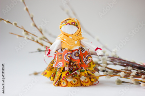 Handmade textile doll with pussy-willow on white background. photo