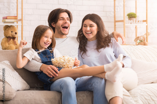 Little Girl Watching Comedy Movie With Mom And Dad At Home