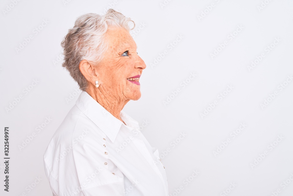 Senior grey-haired woman wearing elegant shirt standing over isolated white background looking to side, relax profile pose with natural face with confident smile. Senior grey-haired woman wearing elegant shirt standing over isolated white background looking to side, relax profile pose with natural face with confident smile.