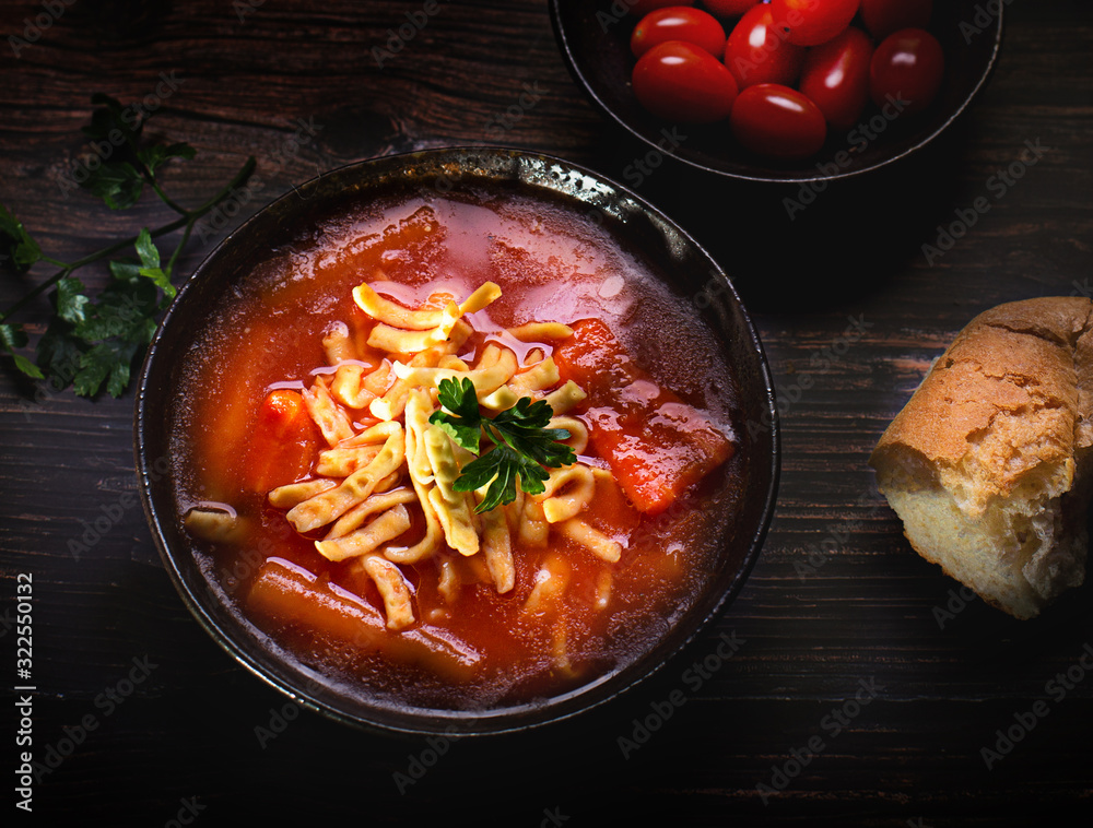 Tomato soup with noodles on a wooden table