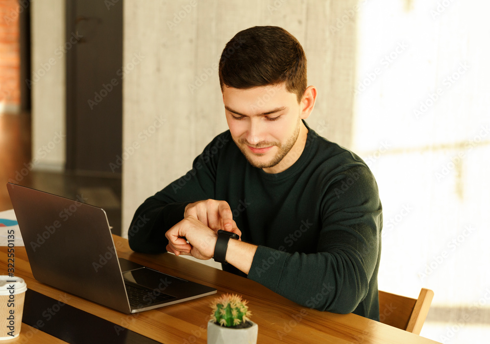 Office Worker At Laptop Checking Time Sitting In Office Office Worker At Laptop Checking Time Sitting In Office