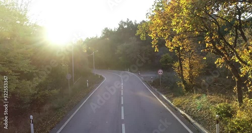 Drone slowly lifting off the ground, sun rays shining. Aerial view