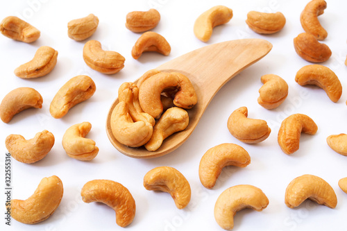 Cashews nut in wooden spoon isolated on white background.
