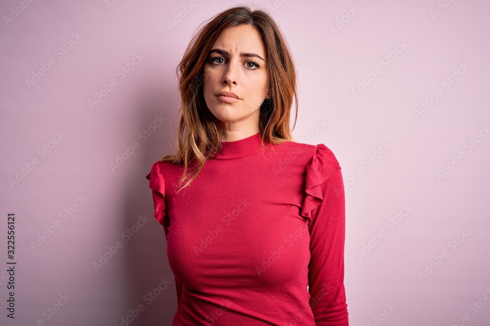 Young beautiful brunette woman wearing casual sweater stnding over pink background with serious expression on face. Simple and natural looking at the camera. Young beautiful brunette woman wearing casual sweater stnding over pink background with serious expression on face. Simple and natural looking at the camera.