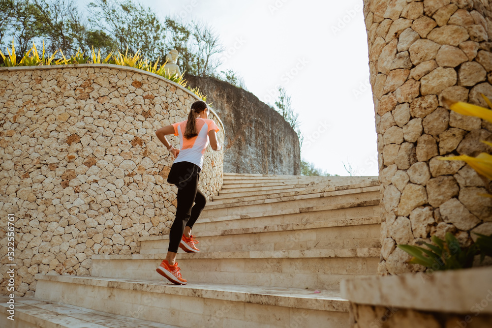Runner athlete running on stairs. woman fitness jogging workout wellness concept. Runner athlete running on stairs. woman fitness jogging workout wellness concept.