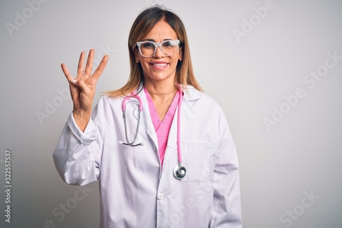 Middle age beautiful doctor woman wearing pink stethoscope over isolated white background showing and pointing up with fingers number four while smiling confident and happy.